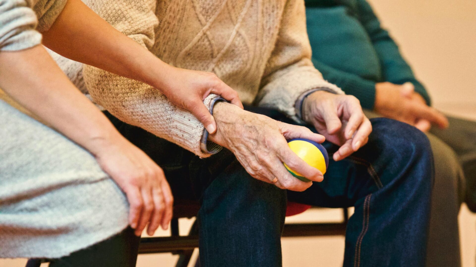 Betreuungskraft unterstützt Klienten bei einer Aktivierungsübung